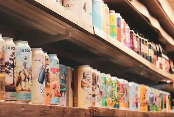 Shelves stocked with a variety of packaged beverages in a retail store.