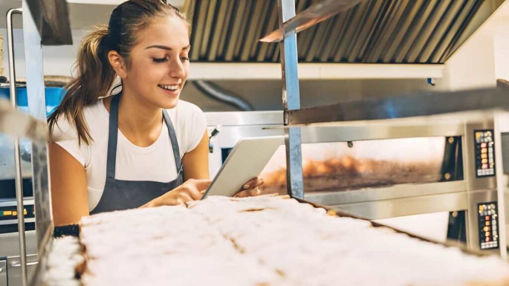 Bakery employee using a tablet to manage orders through Amazon Cin7 Core Integration.