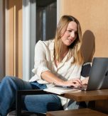Professional working on a laptop in a modern office lounge.
