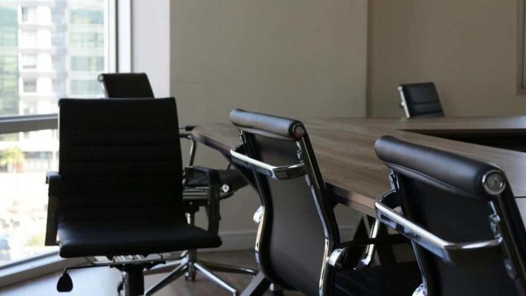 Empty conference room with office chairs around a meeting table.