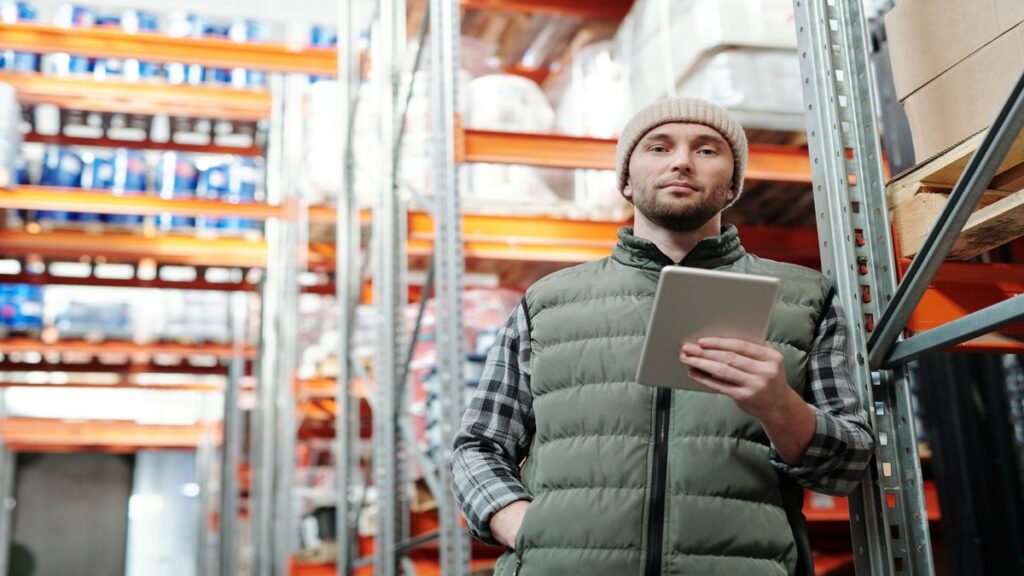 Warehouse employee using wholesale accounting services for inventory records