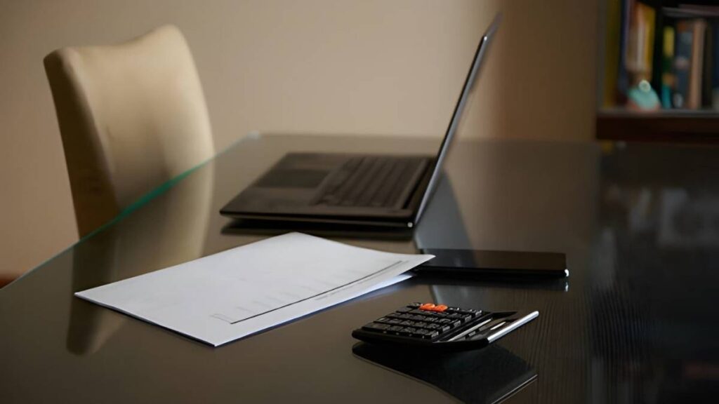 Empty office desk with calculator and documents
