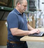 Warehouse employee updating inventory records on a laptop