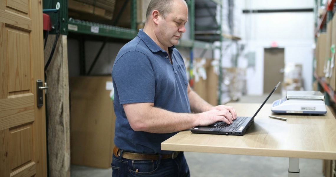 Warehouse employee updating inventory records on a laptop